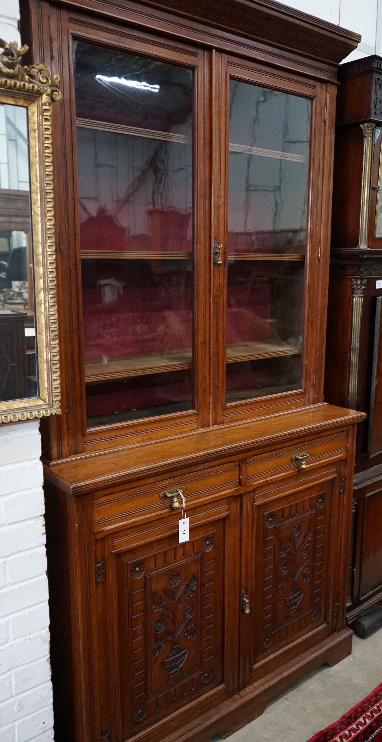 A late Victorian walnut bookcase cupboard, width 121cm, depth 48cm, height 236cm